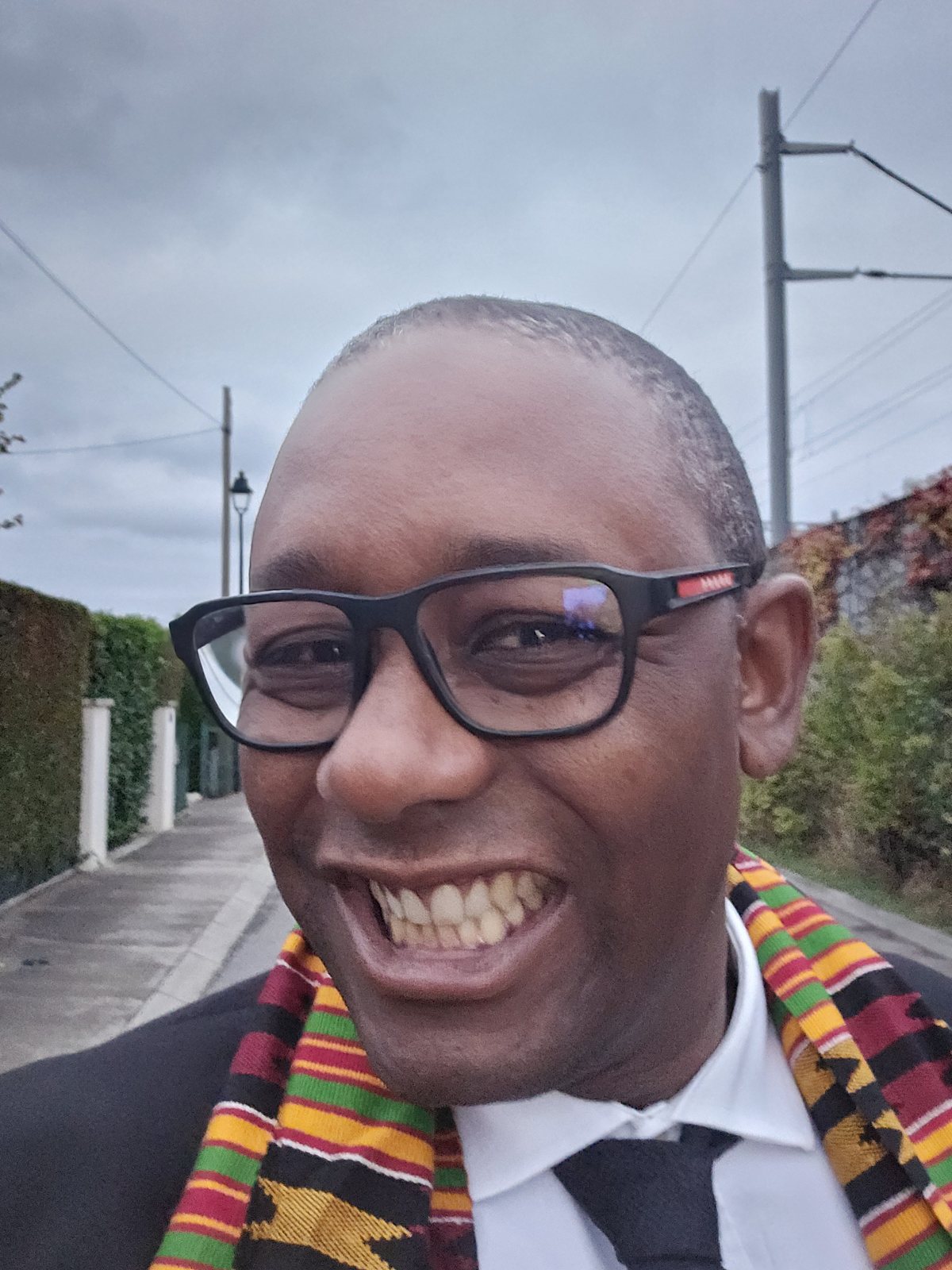 Kofi Nyamekye laughing, wearing a kente stole